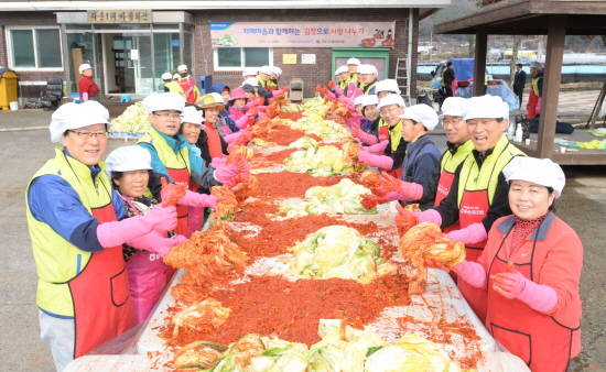 김용환 NH농협금융 회장(왼쪽 첫 번째)과 임직원들이 24일 자매결연마을인 강원도 홍천군 왕대추마을을 찾아 마을 주민들과 함께 소외계층에게 전달할 사랑의 김장김치를 담그고 있다. 