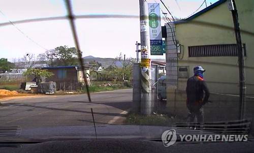 지난20일 오전 경산시 남산면 자인농협 하남지점 앞에 있던 농협 총기 강도사건 용의자의 모습 / 연합뉴스 