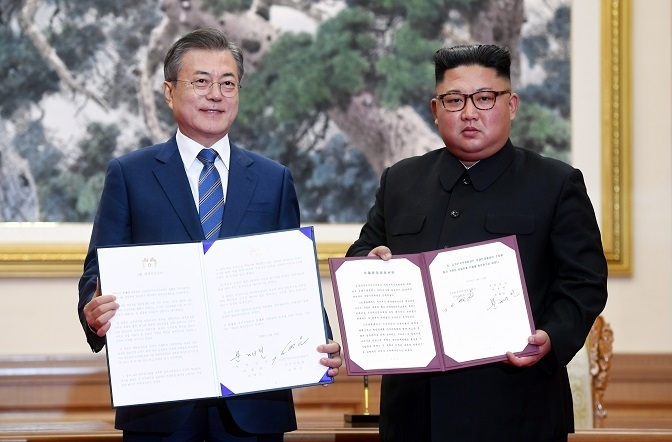 문재인 대통령과 김정은 북한 국무위원장이 지난 19일 <9.19 평양공동선언>에 서명한 후 함께 합의서를 펼쳐들고 사진을 찍고 있다.[사진=평양사진공동취재단]