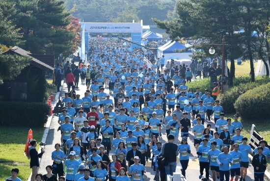 지난 13일 서울 상암동 월드컵공원 잔디장에서 개최된 '2018 슈퍼블루 마라톤 대회' 에서 참가자들이 달려나가는 모습. <사진=롯데 제공>