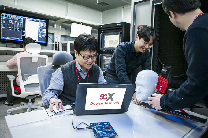 SK텔레콤 5G 디바이스 테스트 랩 연구원들이 계측 장비로 5G 디바이스를 테스트하고 있는 모습. <사진=SK텔레콤 제공>
