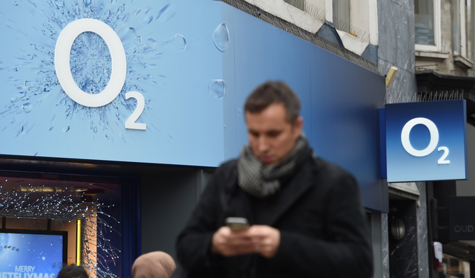 런던 O2 간판 앞을 지나면서 휴대전화를 살펴보는 시민. <사진=연합뉴스>