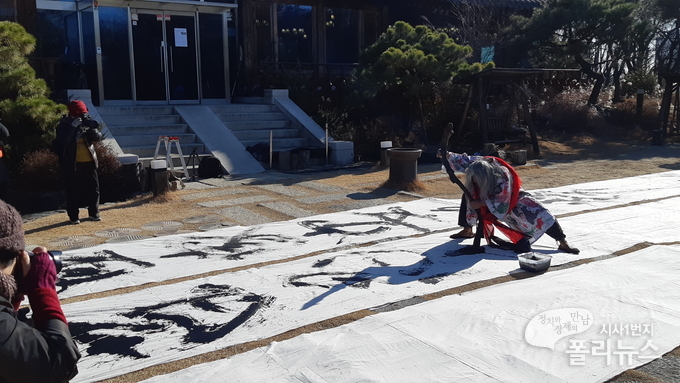 쌍산 김동욱이 광개토대왕 기념조형물 앞에서 안중근 의사 어록을 옮겨 적는 퍼포먼스를 하고 있다. <사진=광개토대왕 사물놀이단>