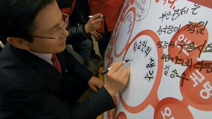 황교안 자유한국당 대표 '자유시민정치축제' 행사장의 한 코너, '대한민국을 살립시다' 라는 게시판에 서명하며 퍼포먼스에 참여하고 있다. <사진=한국당 부산시당>