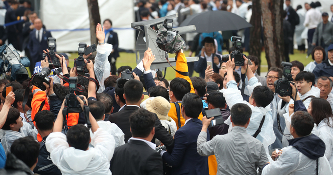 한 시민이 황교안 자유한국당 대표를 향해 플라스틱 의자를 던지며 격렬하게 항의하고 있다 <사진=연합뉴스>