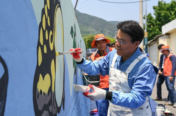 포스코 최정우 회장이 24일 광양 섬거마을에서 임직원들과 벽화그리기 봉사활동을 하고 있다.<사진=포스코 제공>