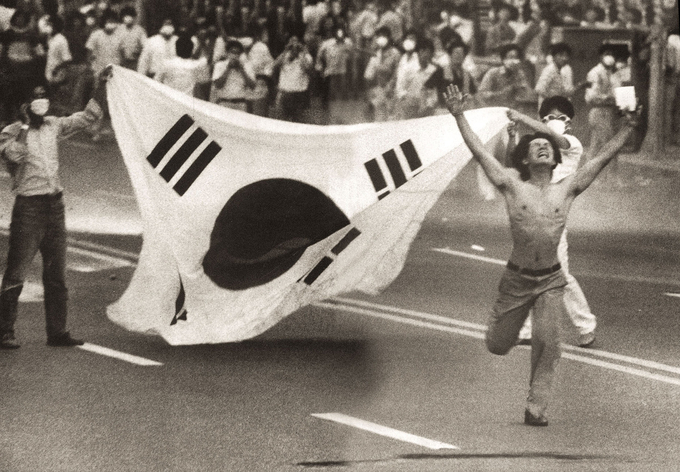 1987년 6월 26일 부산 문현동에서 최루탄을 발사하는 경찰을 향해 시위자가 '최루탄을 쏘리마라'며 달려가고 있는 모습 <사진=민주화운동기념사업회 제공>: