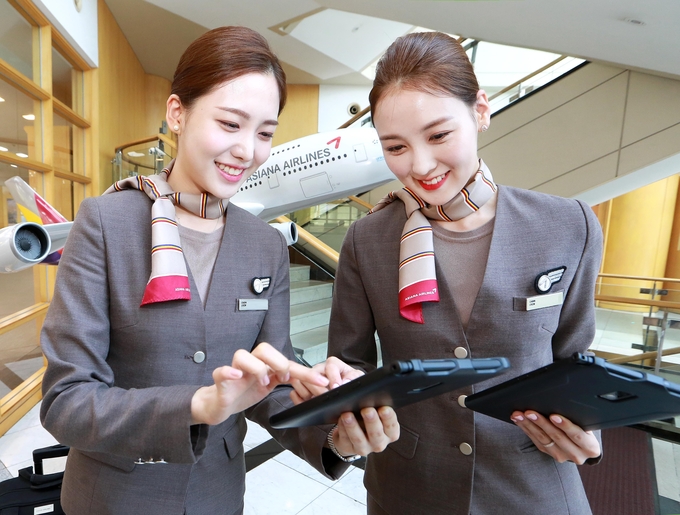 서울시 강서구 오쇠동 아시아나항공 본사에서 아시아나항공 캐빈승무원들이 새롭게 지급받은 태블릿 PC를 통해 스마트워크 플랫폼인 A-tab을 통해 스케줄을 확인하고 있다.<사진=아시아나항공 제공>