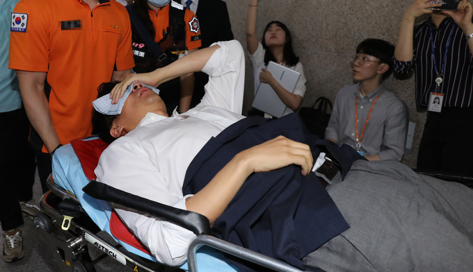 11일째 단식중인 권성주 혁신위원이 몸싸움 끝에 쓰러져 구급차로 이송되고 있다 <사진=연합뉴스>