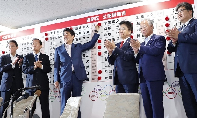 한국에 대한 경제보복 조치를 취한 아베 신조 일본 총리가 지난 21일 참의원 선거 후 당선자들 이름 위에 꽃을 붙이고 있다.[사진=연합뉴스]