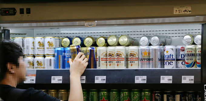 최근 일본상품 불매운동이 맥주시장 판도에도 영향을 미치면서 국내 맥주3사의 해외맥주 판매 유통망에도 관심이 모이고 있다. 최근 서울 시내 대형마트 주류 진열대의 캔맥주를 살펴보고 있는 한 소비자의 모습. <사진=연합뉴스>
