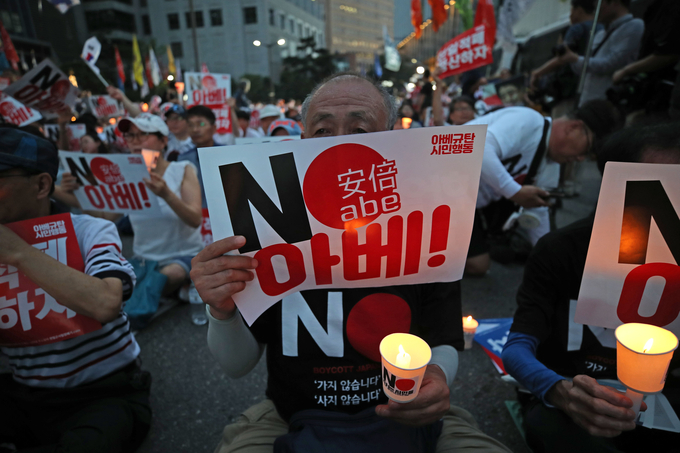 10일 오후 서울 종로구 주한 일본대사관 앞에서 열린 '아베규탄 4차 촛불문화제'에서 참석자들이 촛불과 손피켓을 들고 있다. (사진=연합뉴스)