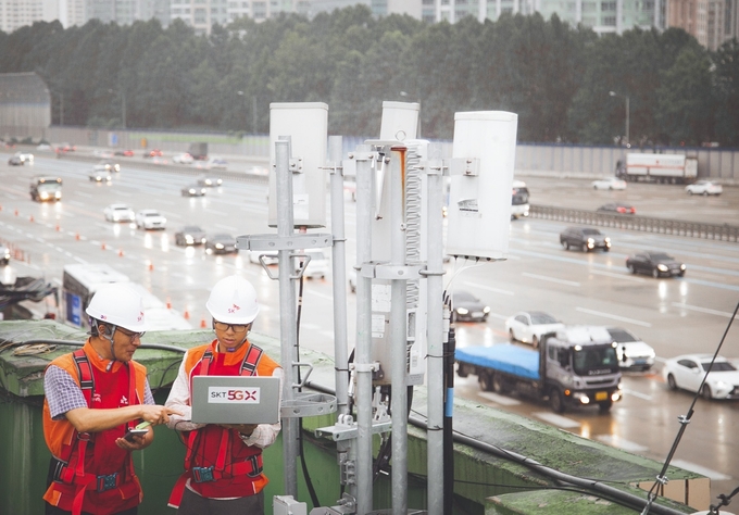 SK텔레콤 직원들이 고속도로 인근에서 5G 네트워크를 점검하고 있는 모습 <사진=SK텔레콤 제공>