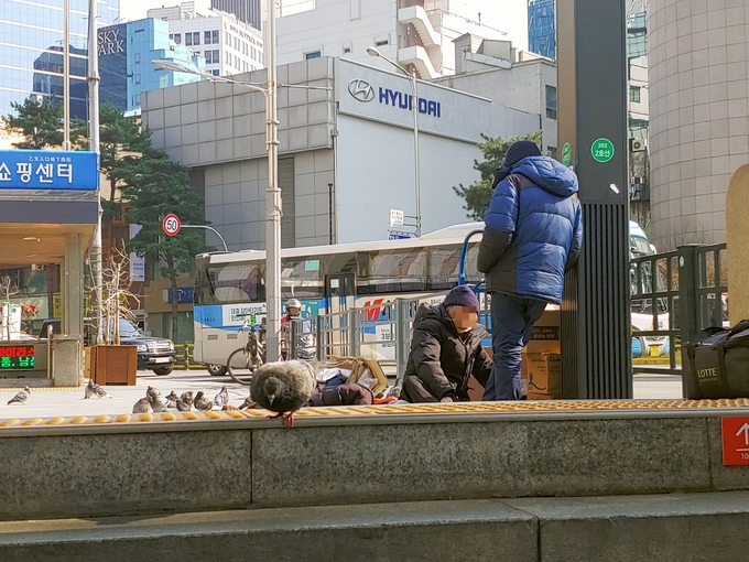 지하철 을지로입구역 앞에 침난을 깔고 있는 노숙인 할머니. 다행히 마스크를 가지고 있지만 추운 날씨에 면역력 저하가 의심된다. <사진=안희민 기자>