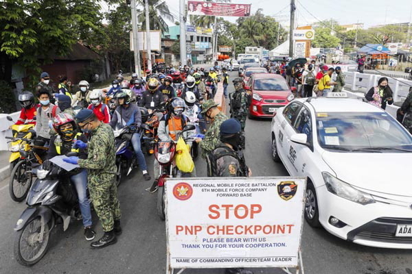 17일(현지시간) 필리핀 루손섬의 메트로 마닐라 지역에 있는 불라칸주와 칼로오칸시 경계의 검역소에서 오토바이 운전자들이 코로나19 관련 검사를 받고 있다. <사진=연합뉴스>