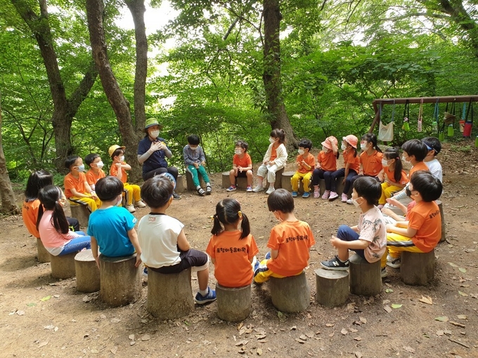 도음산유아숲체험원에서 유아숲지도사와 함께 숲체험프로그램에 참가중인 유아들 모습.