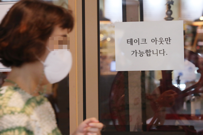 정부가 수도권에 적용된 '사회적 거리두기 2.5단계'를 연장하기로 4일 오후 공식 발표했다. 사진은 이날 서울의 한 카페에 포장 판매만 가능함을 알리는 안내문. <사진=연합뉴스> 