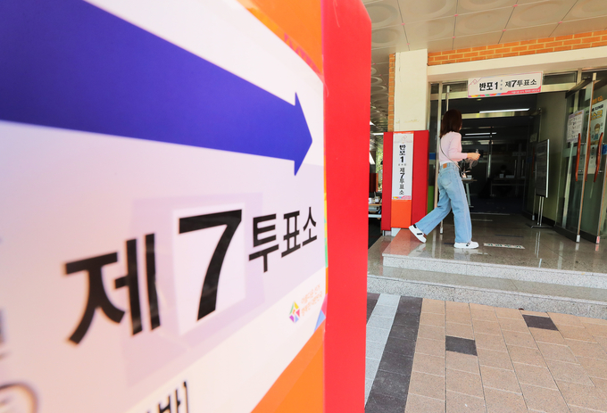 4·7 서울시장 보궐선거일인 7일 오후 직장인들이 서울 중구문화원에 마련된 투표소 앞을 지나고 있다. <사진=연합뉴스>