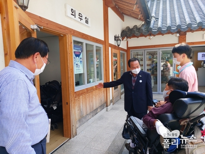 김영만 군수가 최창현 센터장에게 의무실 앞 턱을 없애 휠체어가 자유롭게 드나들 수 있도록 하겠다고 설명하고 있다.