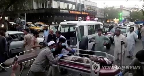 26일 카불 공항 근처에서 일어난 테러로 부상당한 환자를 사람들이 병원에 옮기고 있다. <사진=연합뉴스(로이터 제공)>