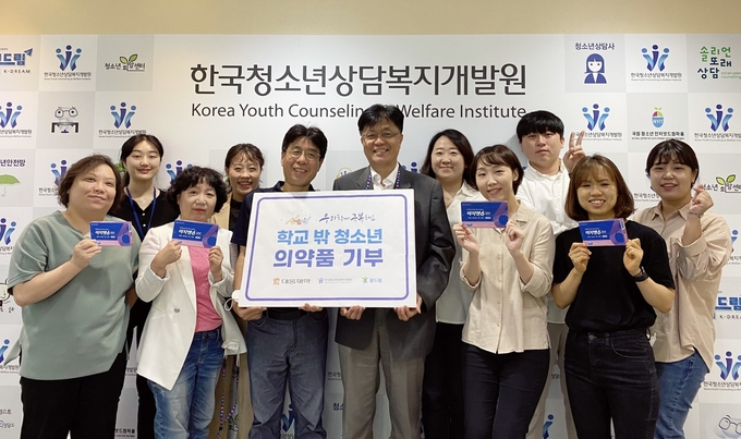 한국청소년상담복지개발원 직원들이 대웅제약에서 전달받은 ‘이지엔6 이브’를 들고 기념사진을 찍고 있다. (사진제공=대웅제약)