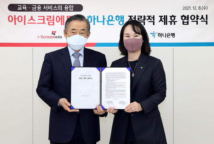 (왼쪽부터) 박기석 아이스크림에듀 대표이사와 김소정 하나은행 디지털리테일그룹 부행장이 협약서를 들고 기념촬영을 하고 있다. <사진=하나은행>