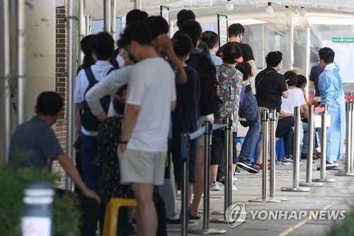 25일 오전 서울 마포구보건소에 마련된 선별진료소에서 시민들이 검사를 기다리며 줄을 서고 있다.