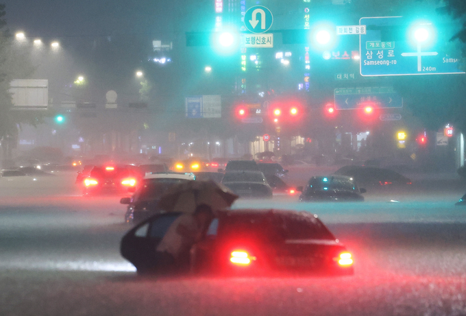 8일 밤 서울 강남구 대치역 인근 도로에서 차량이 침수되자 운전자가 대피하고 있다. 2022.8.8