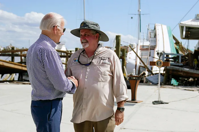 5일(현지시간) 조 바이든 미 대통령(왼쪽)이 플로리다를 찾아 포트 마이어스 비치 시장 레이 머피와 악수하고 있다. 포트마이어스=AFP연합