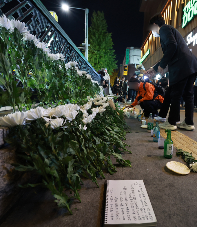 30일 오후 서울 용산구 지하철 6호선 이태원역 1번 출구 앞에 마련된 '핼러윈 인파' 압사 사고 희생자 추모 공간에서 시민들이 헌화하고 있다. 2022.10.30 ( ⓒ연합)
