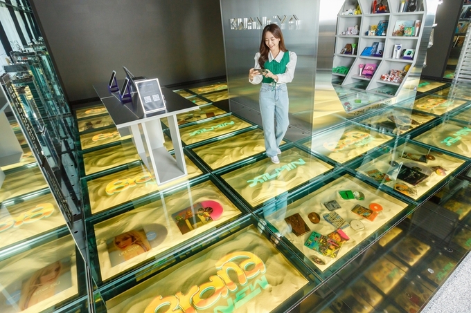 SM브랜드마케팅의 플래그십스토어 '광야@서울'을 방문한 고객이 LG디스플레이 투명 OLED 33대로 구성된 '투명 OLED 플로어 솔루션'을 경험하고 있다.