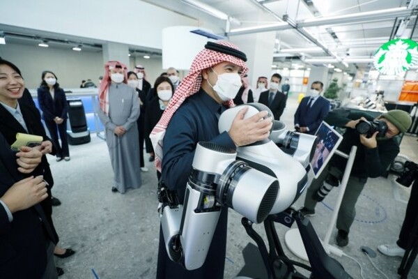 사우디아라비아 자치행정주택부 장관이 네이버 1784에서 로봇팔 앰비덱스와 포옹하고 있다 [사진=네이버]