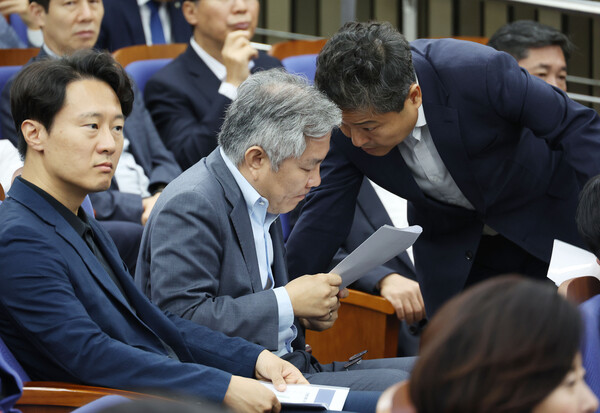 더불어민주당 최강욱 의원(가운데)이 14일 국회에서 열린 의원총회에서 동료 의원과 대화하고 있다. [사진=연합뉴스]