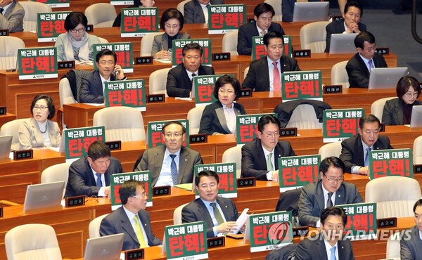 2016년 12월 8일 박근혜 대통령에 대한 탄핵표결을 하루 앞두고 국회 본회의장에서 열린 본회의에서 의원들이 '박근혜 대통령 탄핵!'이라고 쓴 피켓을 앞에 두고 있다. [사진=연합뉴스]