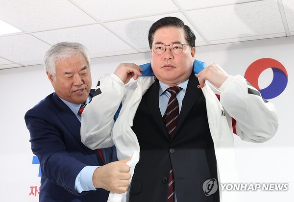 유동규 전 성남도시개발공사 기획본부장이 14일 여의도 자유통일당 당사에서 총선 출마 선언에 앞서 전광훈 목사로부터 당 점퍼를 받아 입고 있다. [사진=연합뉴스]