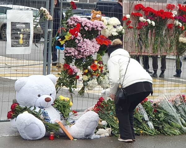 공연장 인근에 마련된 무차별 총격 테러 희생자 추모 공간에 애도객이 꽃을 놓고 있다 [사진=연합뉴스]