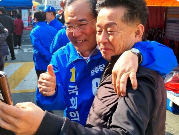 이개호 후보가 셀카를 찍자는 유권자와 어깨동무를 하고 있다[사진=이개호 후보 페이스북]