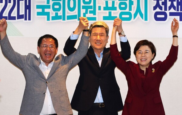 이강덕 시장과 김정재 의원, 이상휘 의원이 손을 맞잡고 만세를 부르고 있다. / 사진=포항시