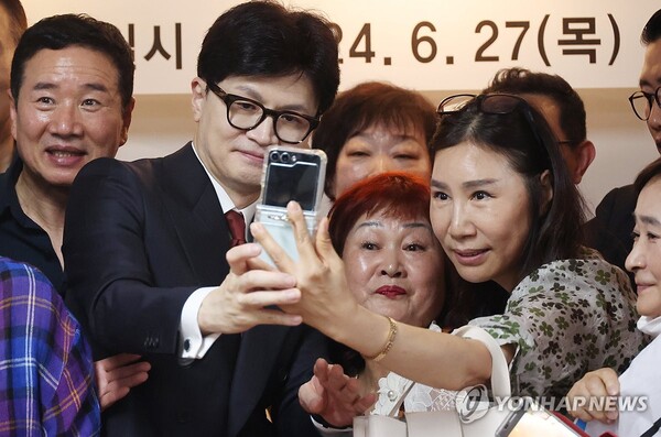 국민의힘 당권주자인 한동훈 전 비상대책위원장이 27일 대구 서구 김상훈 의원 지역구 사무실 건물 한 회의실에서 당원들과 기념 촬영을 하고 있다. [사진=연합뉴스]