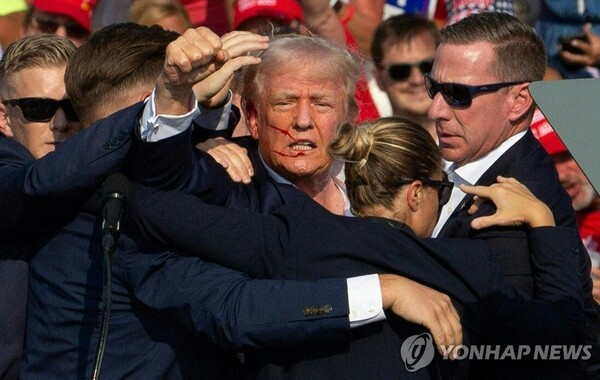 도널드 트럼프 전 미국 대통령이 13일(현지시간) 펜실베이니아주 버틀러에서 야외 유세를 하던 중 피격돼 피를 흘리고 있다. [사진=AFP/연합뉴스]