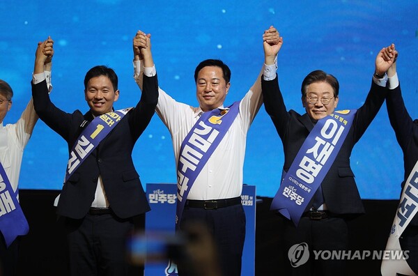 더불어민주당 새 지도부 선출을 위한 지역순회 경선 둘째 날인 21일 오전 강원 홍천군 홍천종합체육관에서 열린 합동연설회에서 김지수(왼쪽부터), 김두관, 이재명 후보가 손을 들어 올리며 당원들에게 인사하고 있다. [사진=연합뉴스]