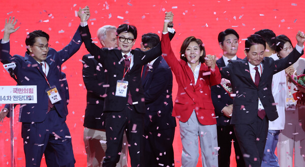 국민의힘 자가 23일 오후 고양 킨텍스에서 열린 국민의힘 제4차 전당대회에서 개표결과 발표 후 경쟁자였던 윤상현, 나경원, 원희룡 후보와 손을 들어올리고 있다. [사진=연합뉴스]