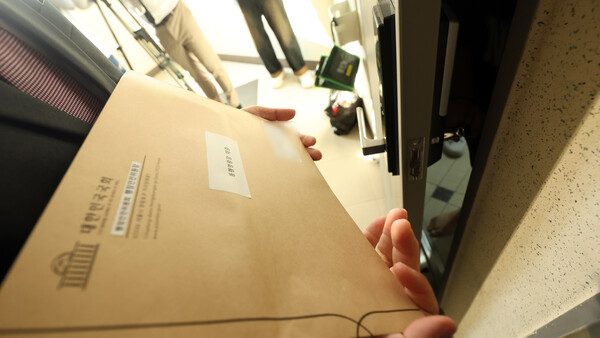 국회 행정안전위원회 입법조사관이 동행명령을 집행하러 10일 오후 경남 창원 명태균 씨 자택을 방문, 명 씨 가족과 대화하고 있다. 국회 행안위는 이날 국정감사에서 증인으로 출석하지 않은 명 씨와 김영선 전 국민의힘 의원에 대한 동행명령장 발부안을 야당 주도로 의결했다. [사진=연합뉴스]