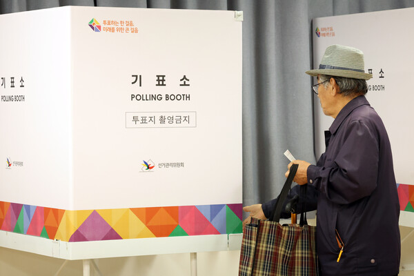 10·16 재보궐선거 본투표가 치러지는 16일 오전 전남 곡성군 겸면투표소에서 군민이 투표용지를 들고 기표소로 들어가고 있다. [사진= 연합뉴스]