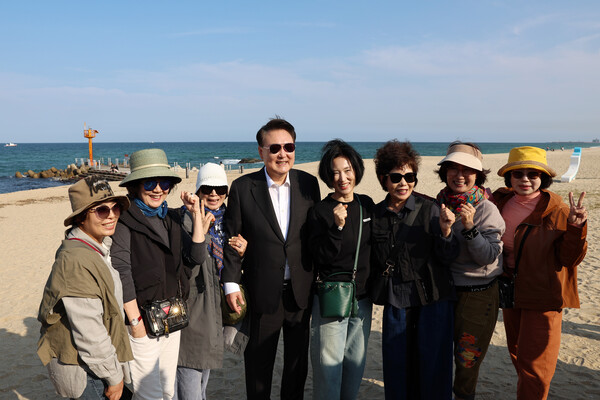 윤석열 대통령이 17일 오후 바르게 살기행사를 마친 후 예고없이 강문해변에 들러 경포바다를 둘러보며 나들이 나온 강릉시민들과 기념촬영을 하고 있다. [사진=대통령실 제공]