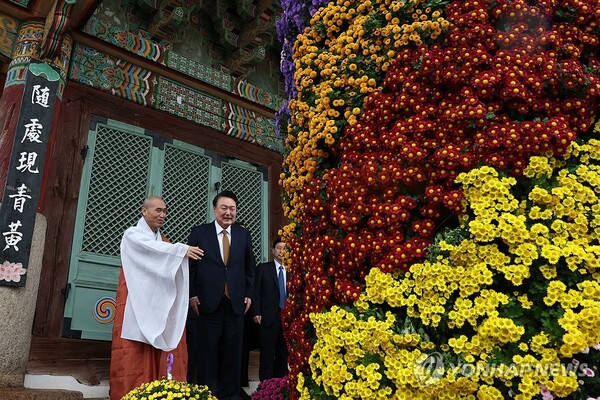 윤석열 대통령이 22일 부산 금정구 범어사를 찾아 대웅전 입구 양쪽에 장식된 국화를 바라보며 주지 정오스님과 대화하고 있다. 2024.10.22 [대통령실 제공. 재판매 및 DB 금지] [사진=연합뉴스]