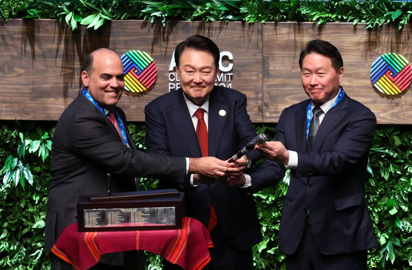 윤석열 대통령과 2025 경주 아시아태평양경제협력체(APEC) CEO 서밋 의장을 맡게 되는 최태원 대한상공회의소 회장이 15일(현지시간) 페루 리마 국립대극장에서 열린 APEC CEO 서밋에서 페르난도 자발라 의장으로부터 의사봉을 인수하고 있다.[사진=연합뉴스]