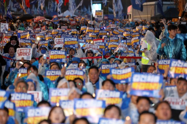 이재명 1심 판결 직후인 16일 오후 서울 광화문 북측광장 인근에서 더불어민주당 주최로 열린 '김건희 윤석열 국정농단 규탄·특검 촉구 제3차 국민 행동의 날' 장외 집회에서 참석자들이 빗속에서도 구호를 외치고 있다.[사진=연합뉴스]