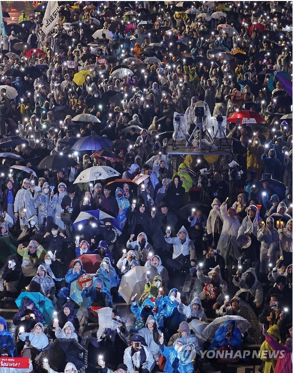 이재명 대표의 1심 판결 직후 16일 열린 첫 윤석열 규탄집회는 빗속에서도 열렸다.  '김건희 특검 수용, 국정농단 규명! 윤석열을 거부한다 시민행진' 집회 참가자들이 휴대폰 불빛을 비추며 정권규탄 구호를 외치고 있다. [사진=연합뉴스]