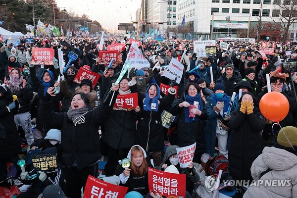 윤석열 대통령 탄핵소추안이 통과된 14일 서울 여의도 국회 앞에서 '윤석열 즉각 퇴진·사회대개혁 비상행동' 주최로 열린 촛불집회에 참가한 시민들이 환호하고 있다. [사진=연합뉴스]